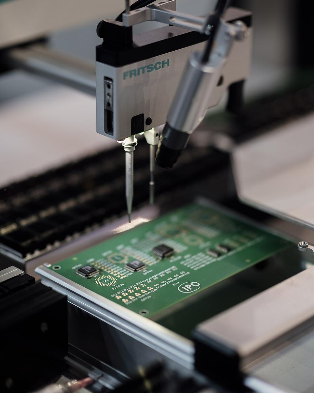 A placement head puts components on a green circuit board